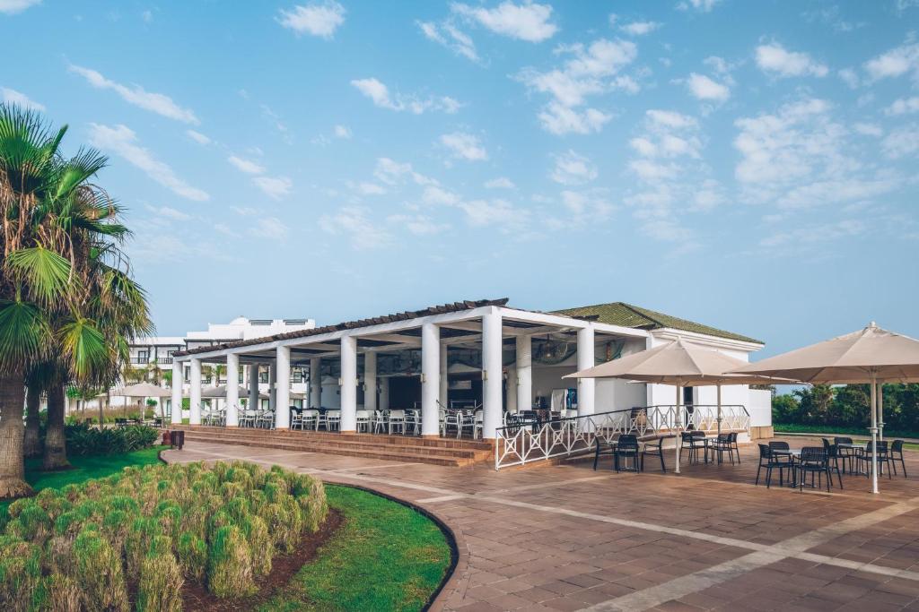 a resort with tables and umbrellas on a patio at Iberostar Waves Saidia in Saidia 