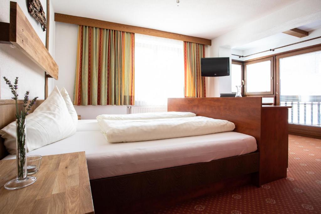 Gemütliches Familienzimmer im Ferienhotel Bergland mit Sitzecke, traditionellen Elementen und Blick nach draußen