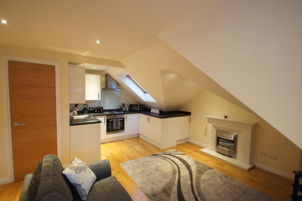 a living room with a couch and a kitchen at Modern, Cosy Apartment In Bearsden with Private Parking in Glasgow