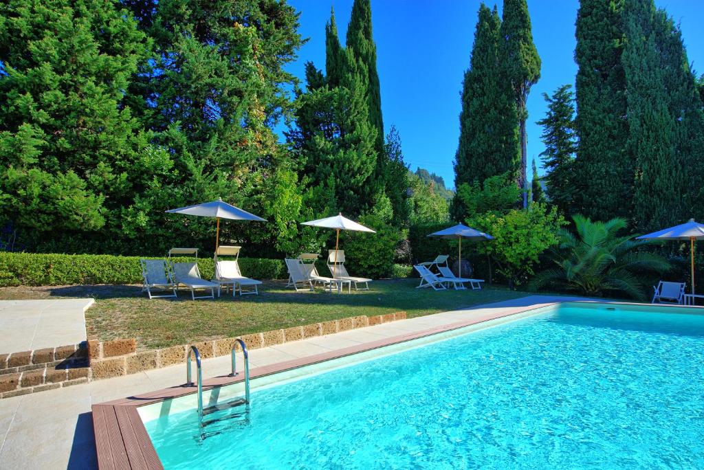 una piscina con sillas y sombrillas en Villa Camaiore by PosarelliVillas en Santa Lucia