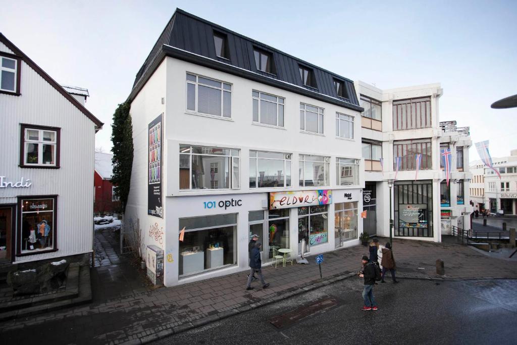 a group of people walking in front of a white building at Odinn Reykjavik Skolavordustigur Apartments in Reykjavík