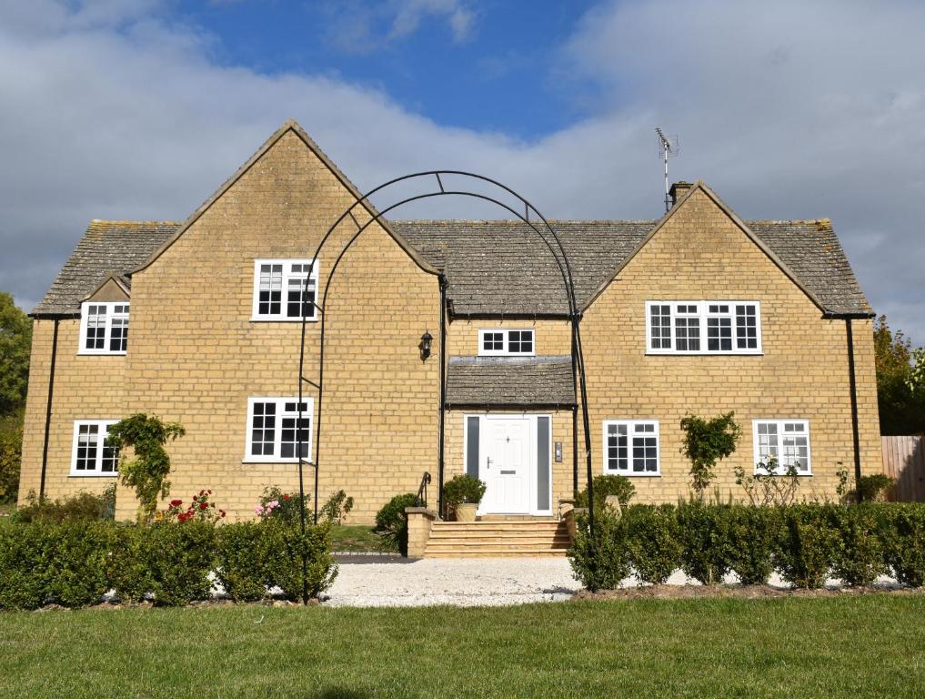 a large brick house with a white door at Staddlestones Broadway in Broadway