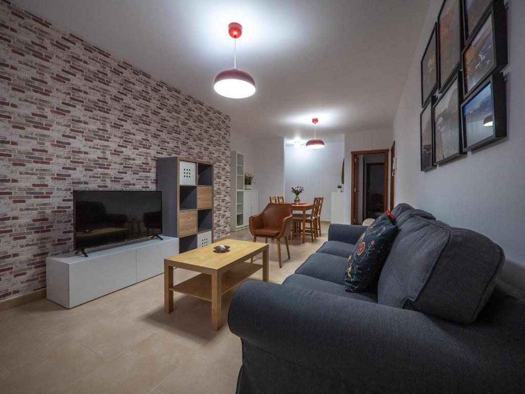 sala de estar con sofá azul y TV en Apartamento nuevo con WiFi en Frontera