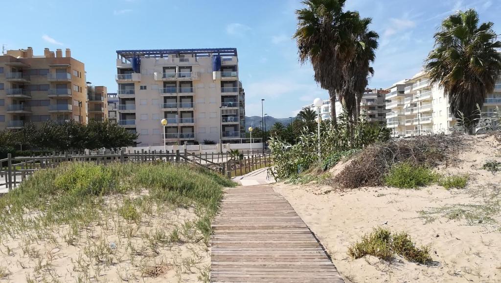 un camino de madera a través de la arena en una playa en Estudio con patio en Daimus niños y mascotas consultar, en Los Mártires