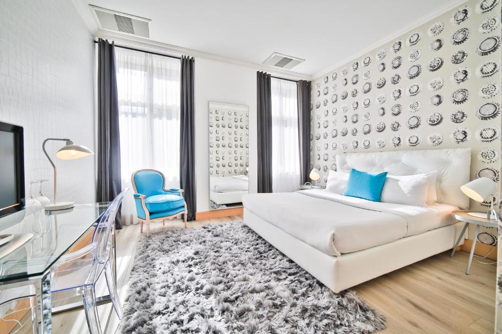 - une chambre avec un lit blanc et une chaise bleue dans l'établissement Friday Hotel, à Prague