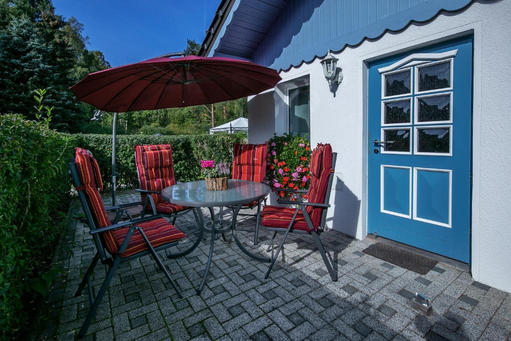 a patio with a table and chairs and an umbrella at Ferienhaus Martina in Bad Brambach