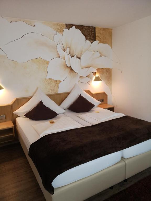 Un dormitorio con una cama grande con un cuadro en la pared. en Hotel DreiKönig & Restaurant SeeGourmet, en Hagnau