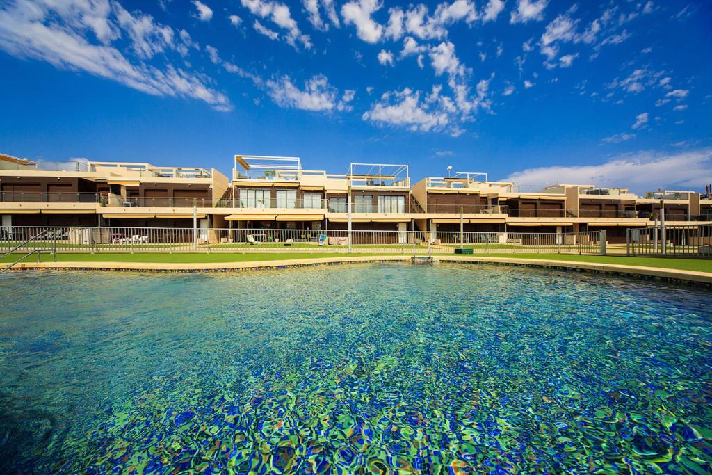 a building with a pool of water in front of it at Penthouse 2 bedrooms in Mil Palmeras in Pilar de la Horadada