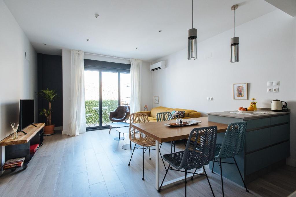 uma cozinha e sala de estar com mesa e cadeiras em Apartamento Alameda em Sevilha