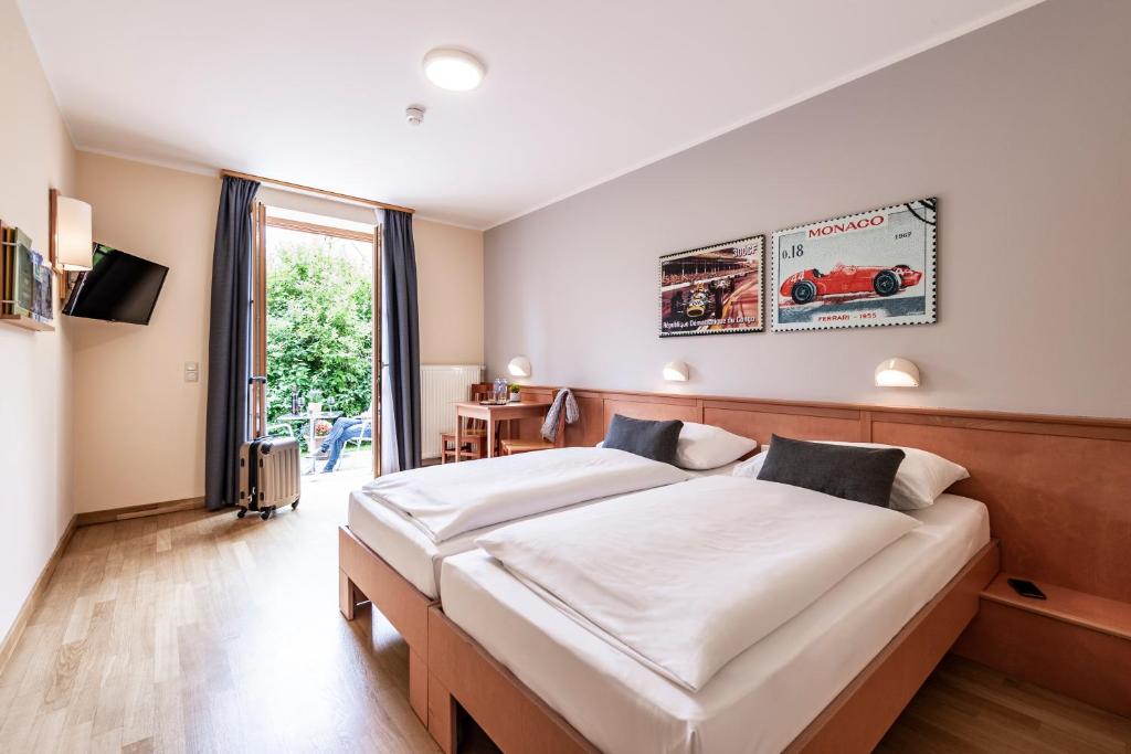 a bedroom with two beds and a large window at JUFA Hotel Seckau in Seckau