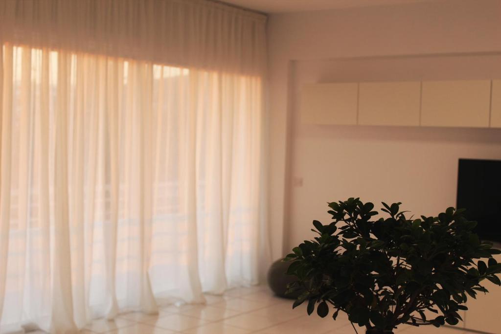 a living room with a curtain and a plant at Olosuites in Limassol