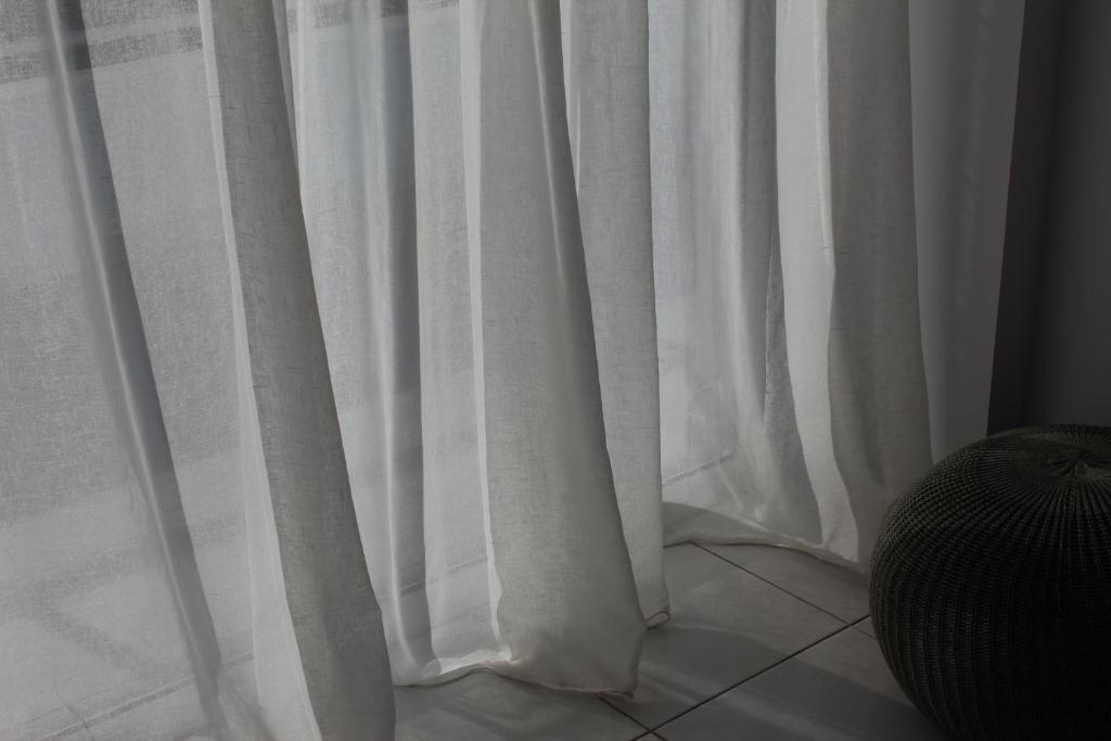 a white curtain sitting on top of a tiled floor at Olosuites in Limassol