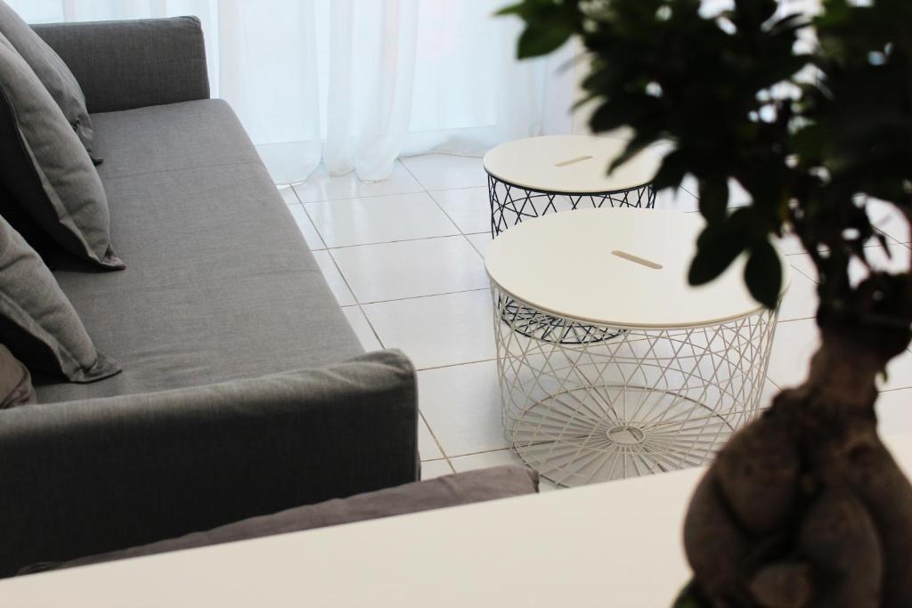 a living room with a couch and a table with a plant at Olosuites in Limassol