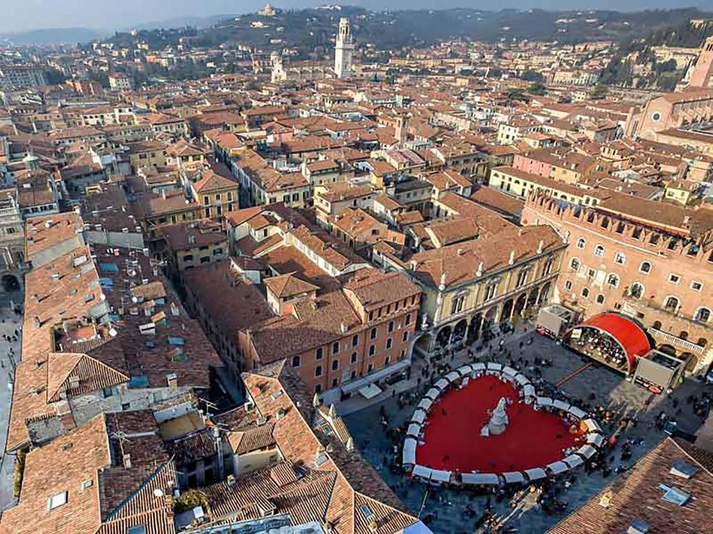 widok z góry na miasto z czerwonym budynkiem w obiekcie Porta Borsari Suite Astori w Weronie