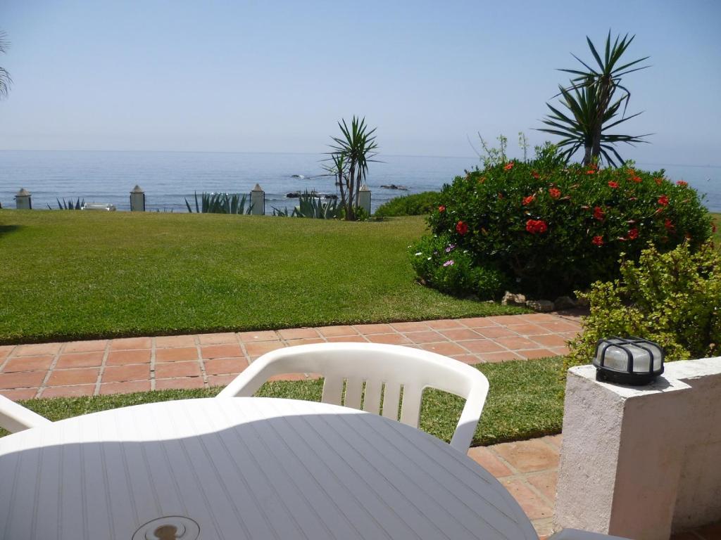una mesa y sillas con el océano en el fondo en Apartamento Playa de la Lucera, en La Cala de Mijas