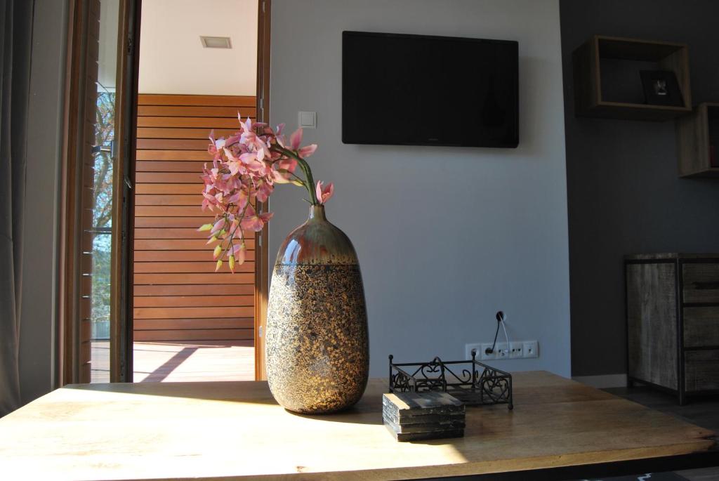 a vase with pink flowers sitting on a table at Ambar Apartament in Gdańsk