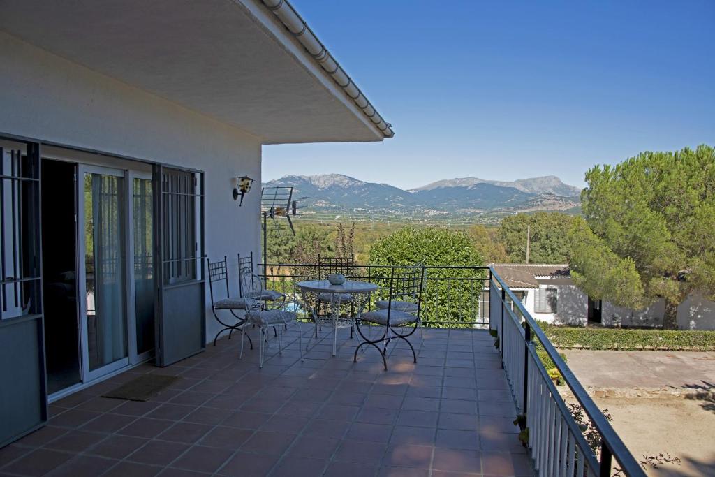 a patio with a table and chairs on a balcony at La "Casita" de la Sierra in Guadarrama