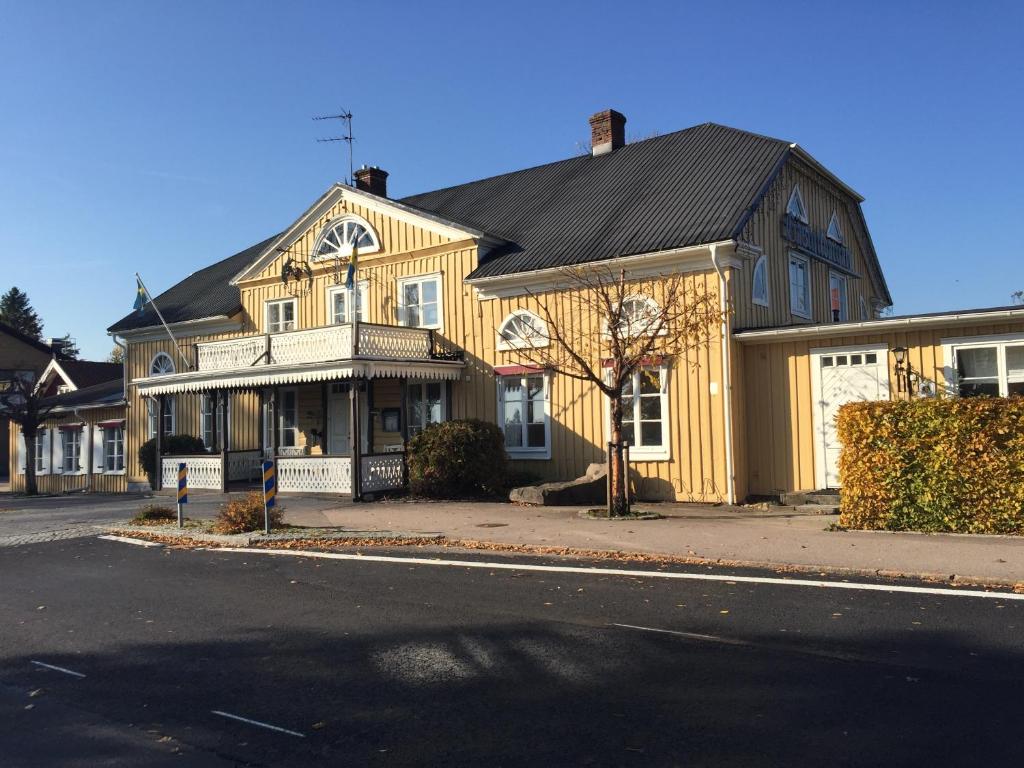 TorupにあるTorups Gästgivaregårdの路上黒屋根の黄色い家