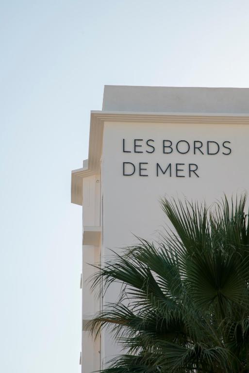 a sign on the side of a building with a palm tree at Les Bords De Mer in Marseille