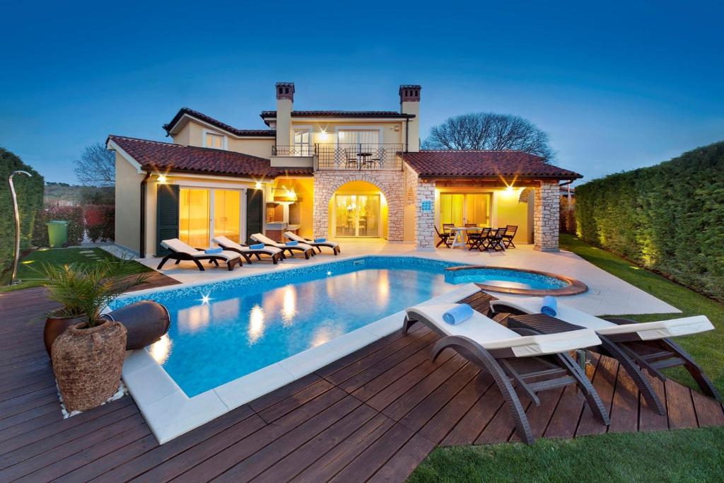 a swimming pool in front of a house at Luxury Villa S Domenica near Poreč with Pool, Wine Cellar and Billiard in Labinci