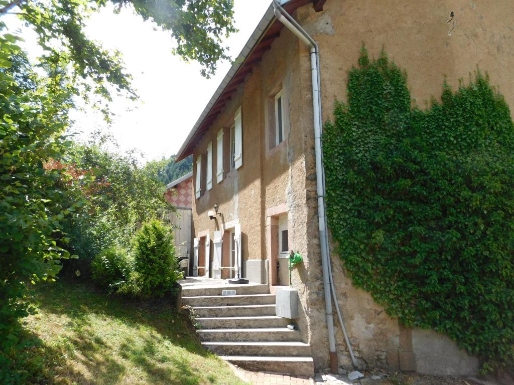 a building with stairs leading up to a house at Gîte l'école est finie 6 personnes 4pièces in Lusse