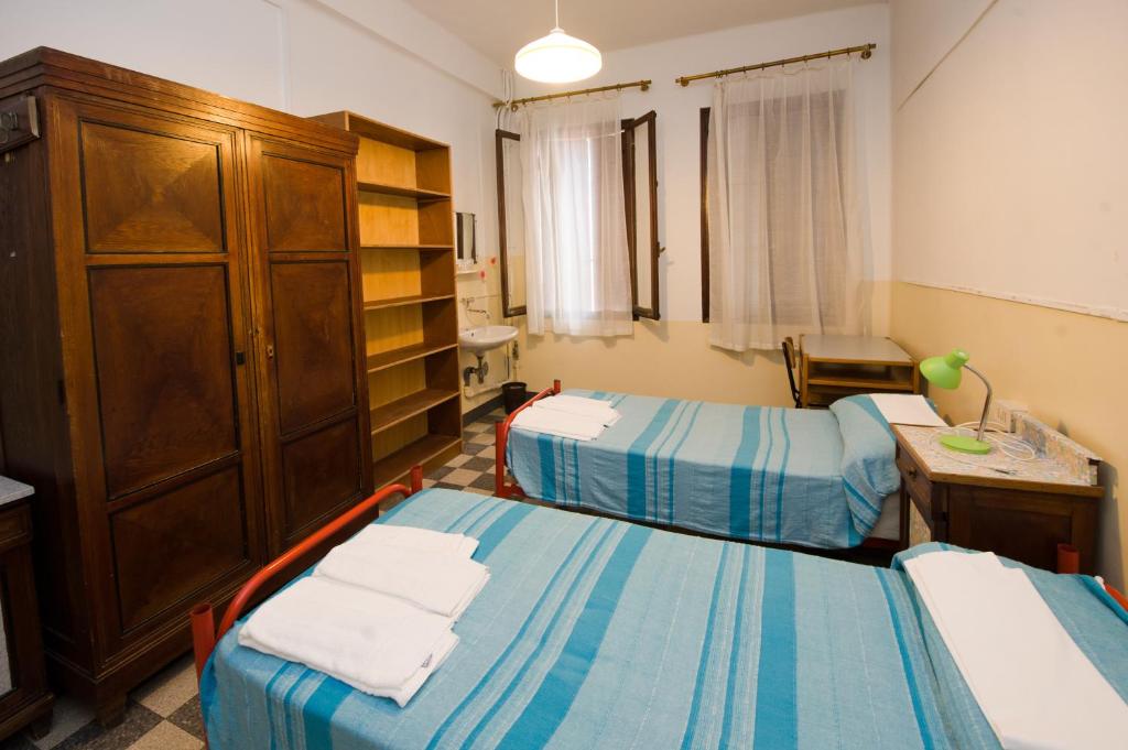 Postel nebo postele na pokoji v ubytování Ostello Domus Civica