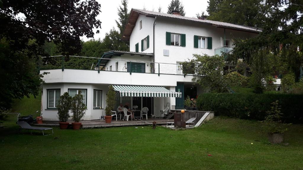 une grande maison blanche avec une terrasse dans la cour dans l'établissement Ferienstudio Traunsee, à Gmunden