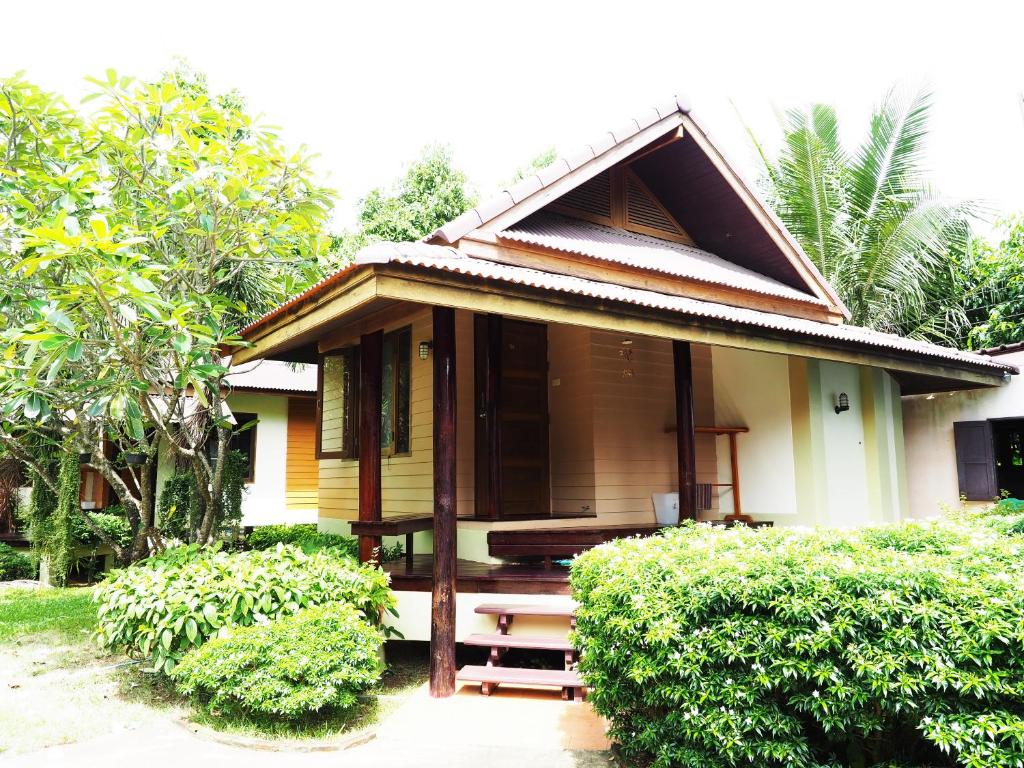 een klein huis met struiken ervoor bij Baan Pun Sook Resort in Chao Lao Beach