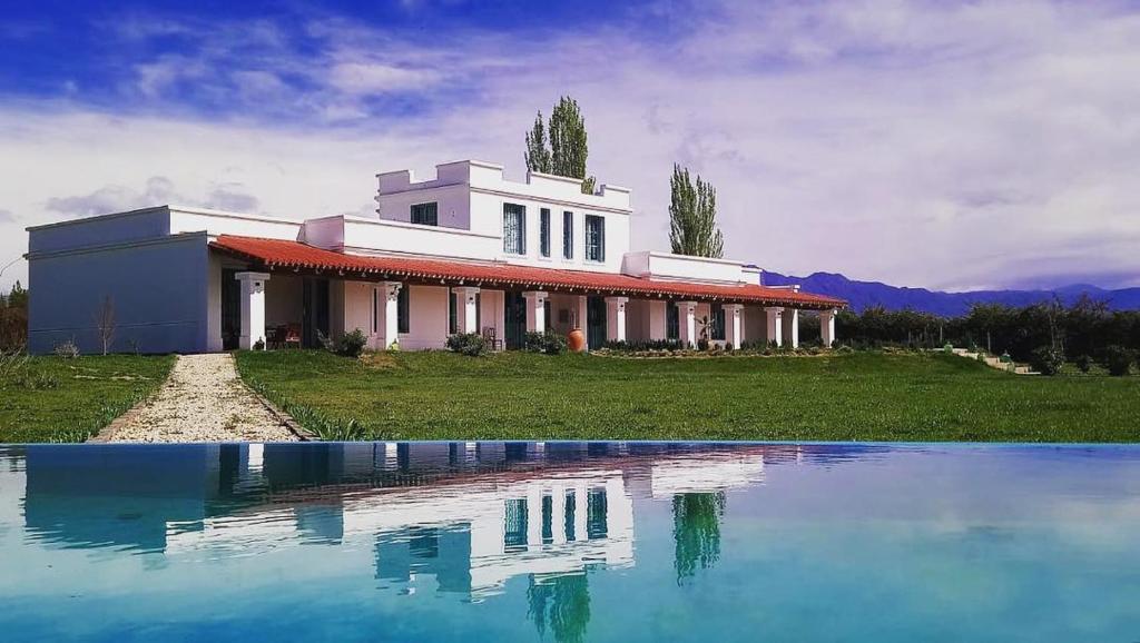 a house with a pool of water in front of it at Villa Trinidad Guesthouse in Ciudad Lujan de Cuyo