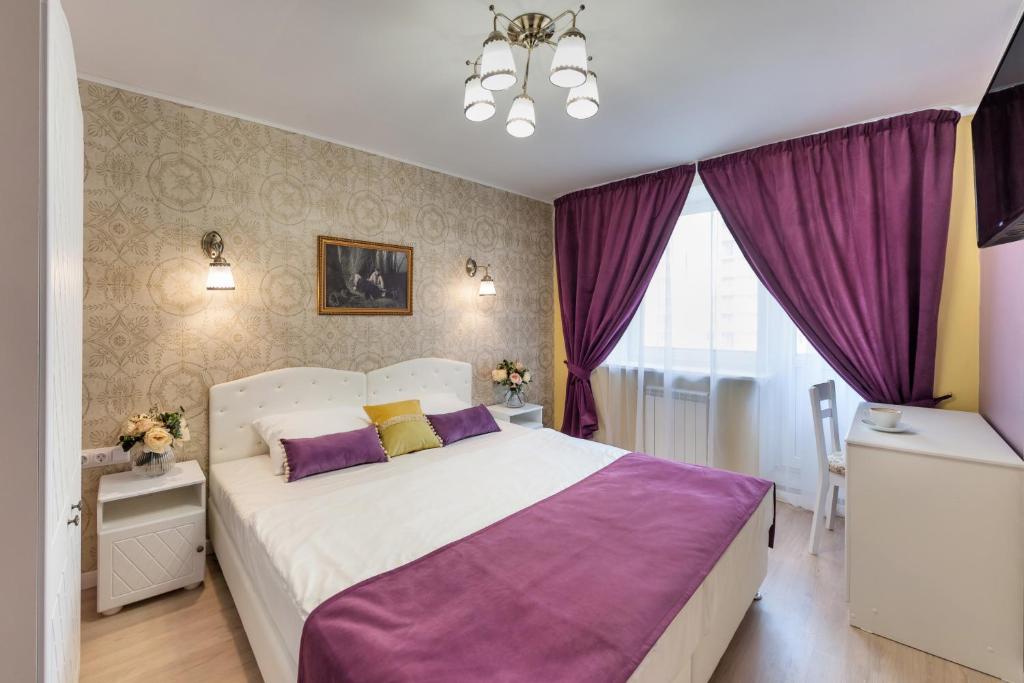 1 dormitorio con 1 cama grande con almohadas moradas y amarillas en Art Hotel Karelia, en San Petersburgo