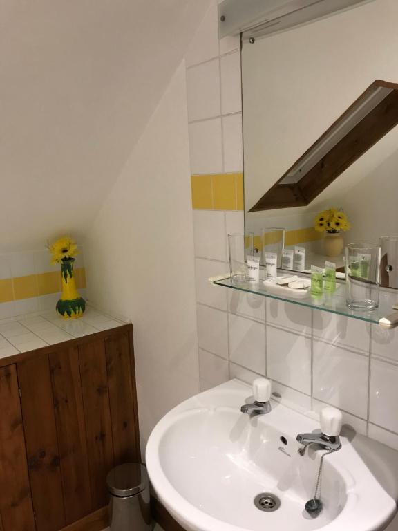 La salle de bains est pourvue d'un lavabo blanc et d'un miroir. dans l'établissement The Pear Tree, à Hook Norton