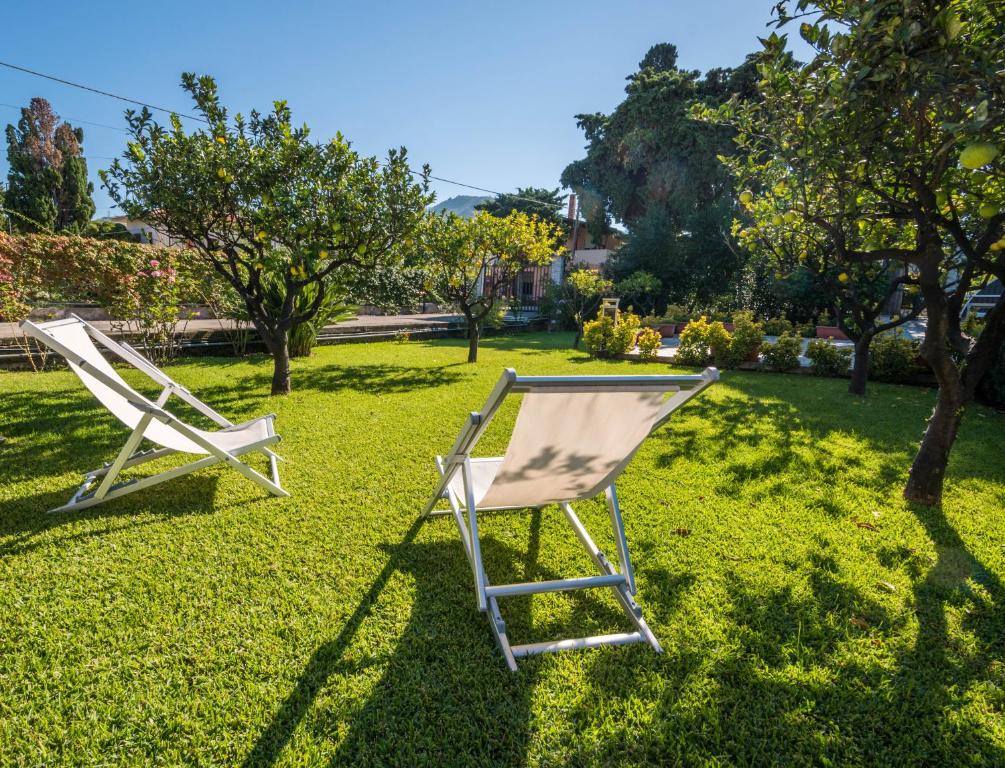 two chairs sitting on the grass in a yard at Villa Francesco...graziosa, moderna, confortevole! in Lascari