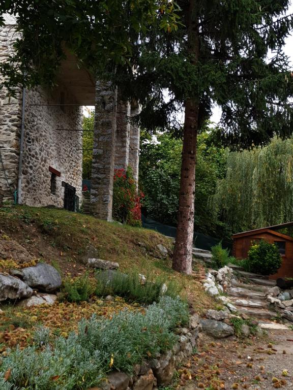 un jardin avec des arbres et des rochers et une maison dans l'établissement villa pura vida, à Saint-Martin-Vésubie