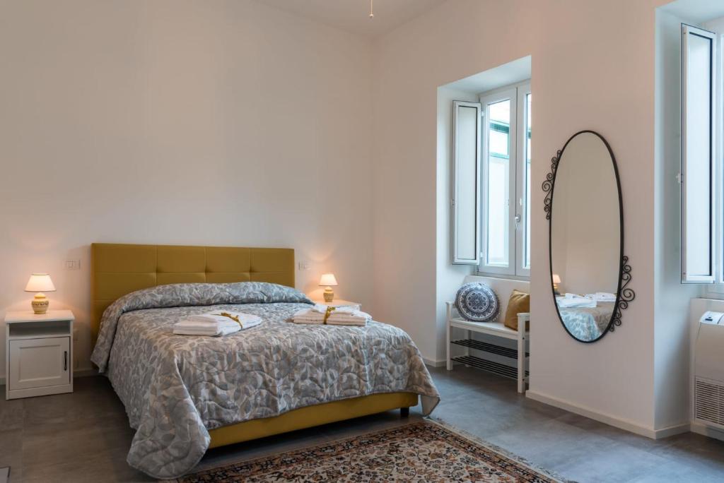 een slaapkamer met een bed en een grote spiegel bij Nonna Vittoria Apartment in Salerno