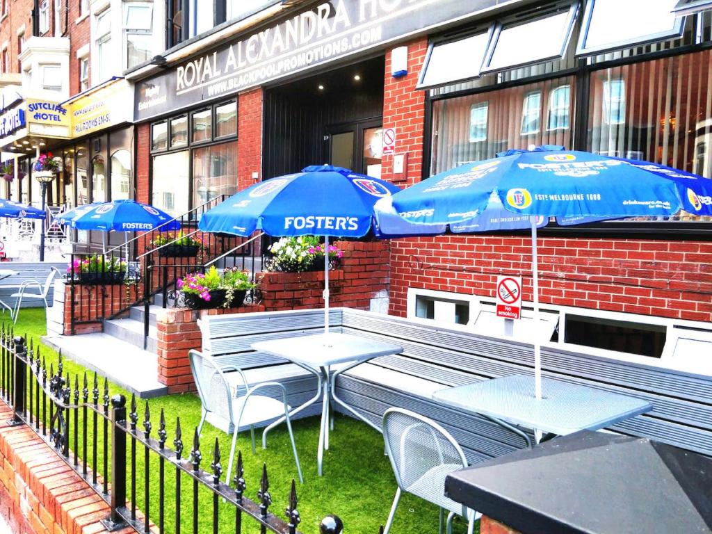 a restaurant with tables and umbrellas in front of a building at The Royal Alexandra Hotel in Blackpool