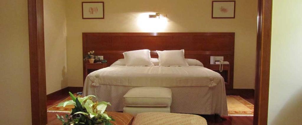 a bedroom with a large bed with a wooden headboard at Bellavista in El Barco de Ávila