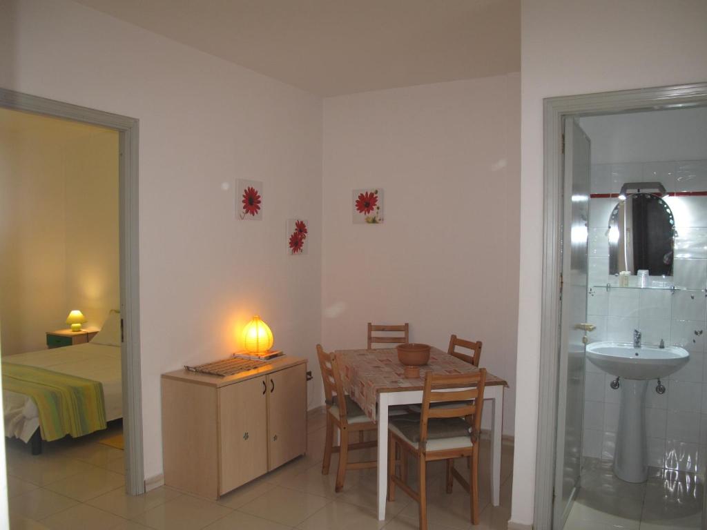 パレルモにあるCasa Il Papiro TRS-IT-SIC-20280のテーブルとシンク付きの部屋、ベッドルーム1室が備わるアパートメントです。