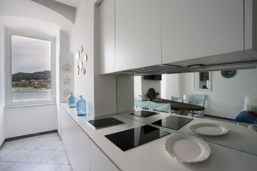 a kitchen with white cabinets and a counter top at Vongola in Portovenere