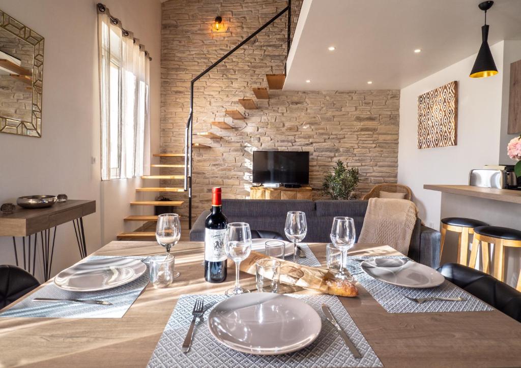 a dining table with a bottle of wine and glasses at Loft de standing Cannes in Cannes