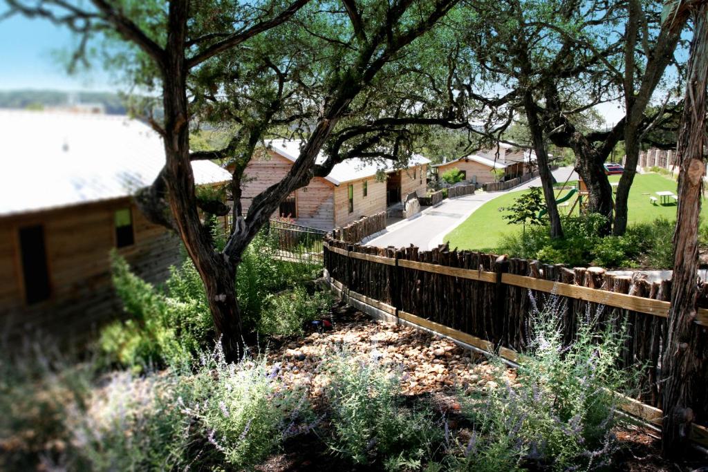 a fence in front of a yard with trees at Hideout on the Horseshoe in Canyon Lake