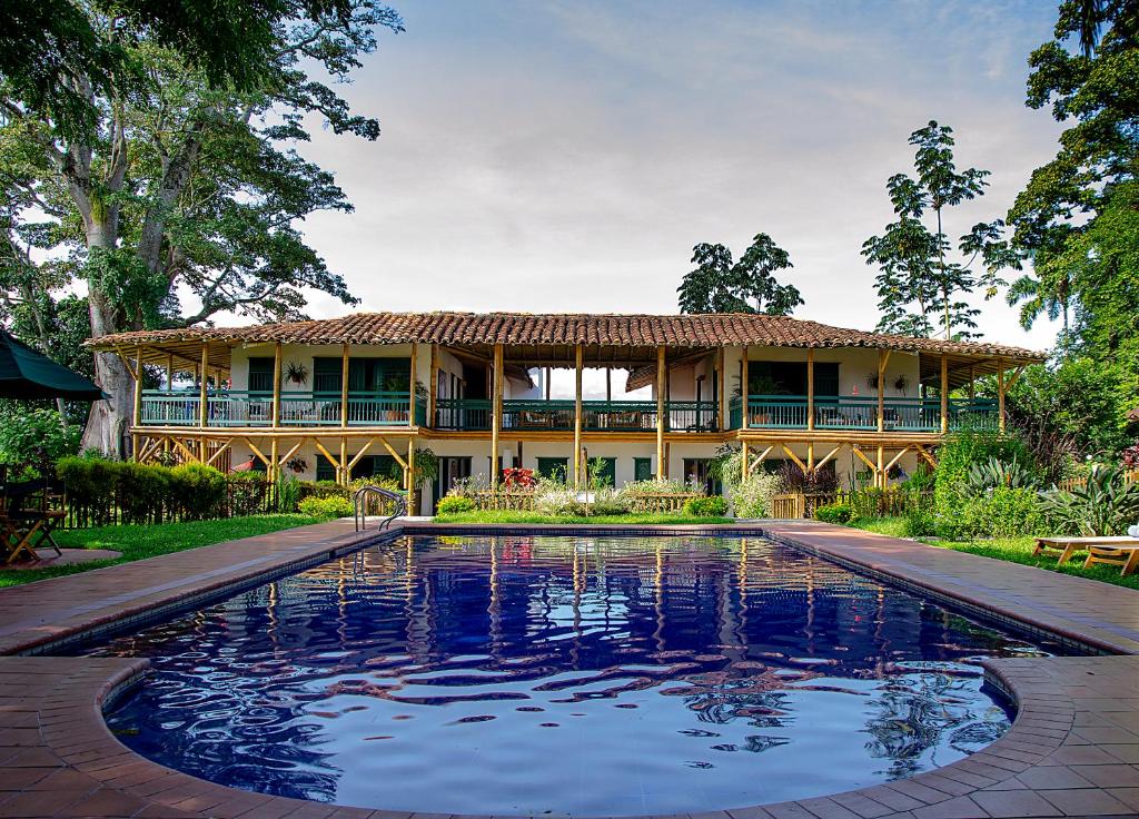 una casa con piscina frente a una casa en Hacienda Bambusa, en El Caimo