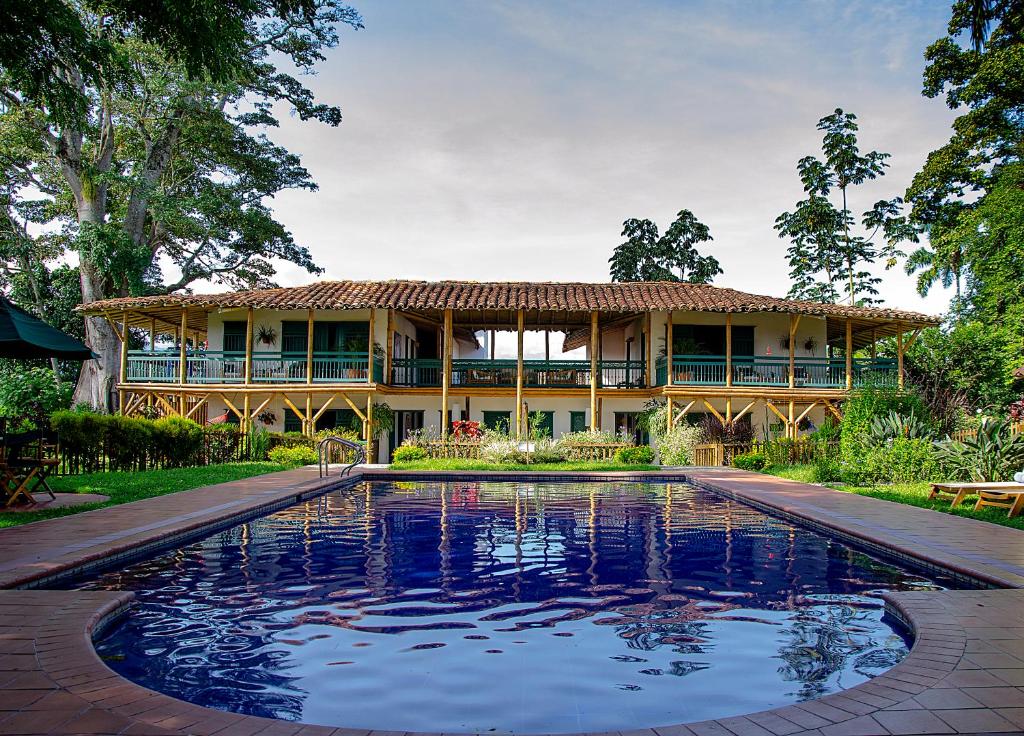 a house with a swimming pool in front of a house at Hacienda Bambusa in El Caimo