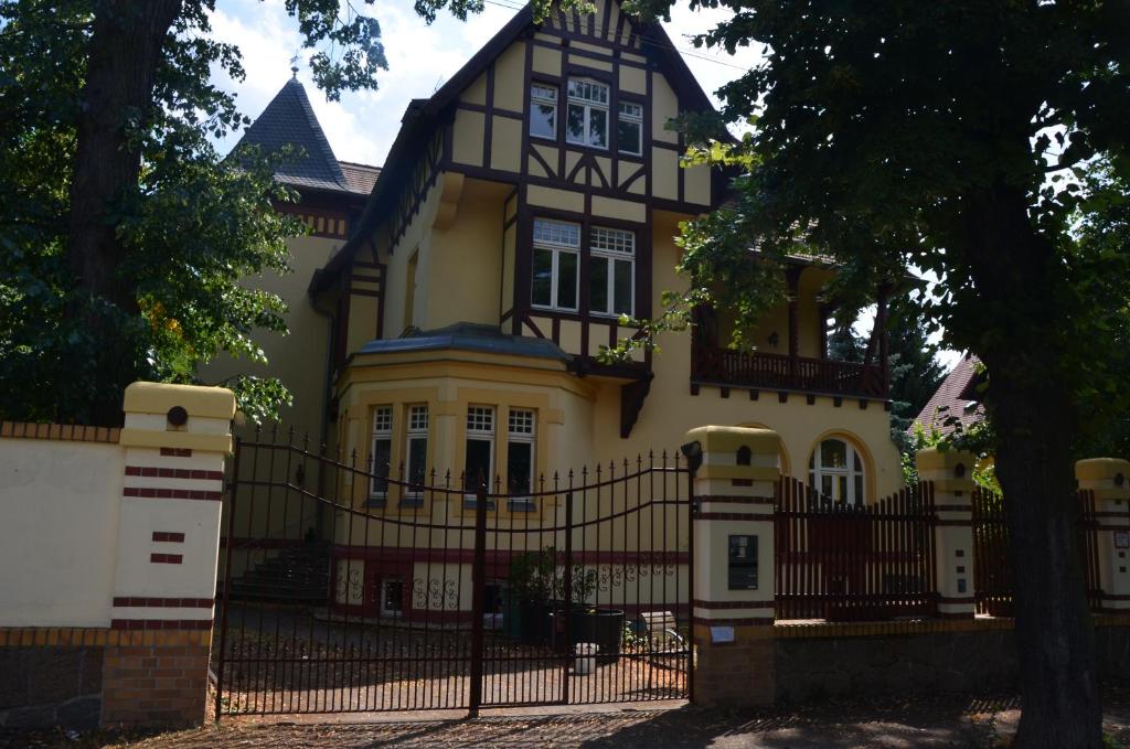 a large yellow and black house with a black fence at Unterkunft Nähe Leipzig Messe in Borsdorf