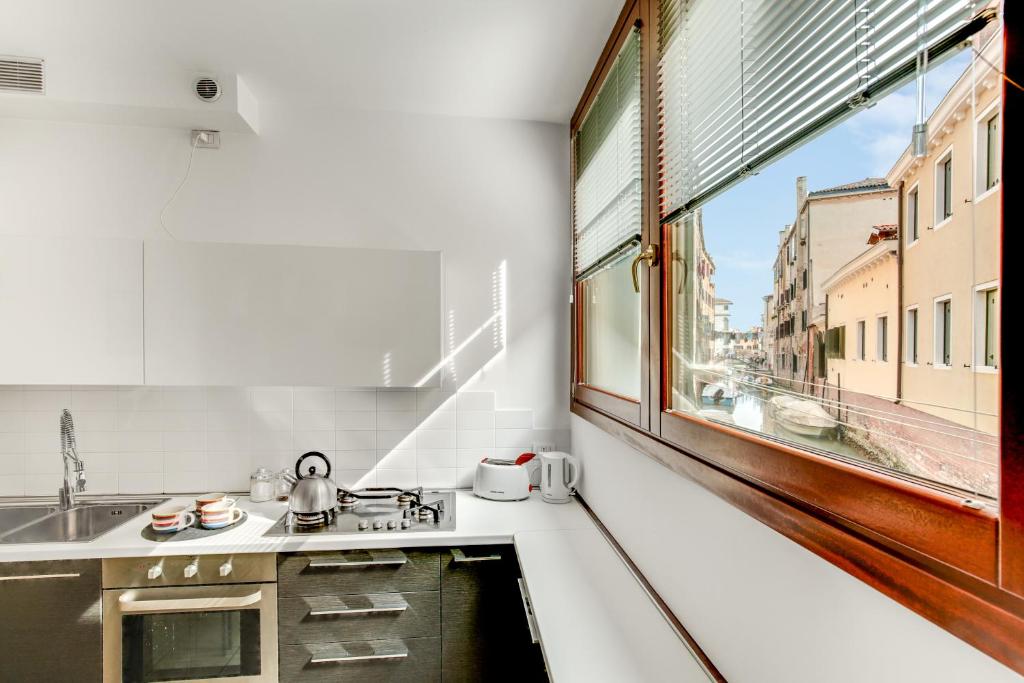 una piccola cucina con lavandino e finestra di Priuli Canal View a Venezia