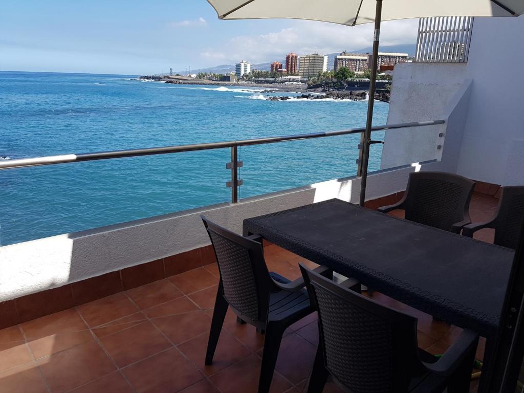 stół i krzesła na balkonie z widokiem na ocean w obiekcie Calle Guajara, 1. Casa Playa Chica w Puerto de la Cruz