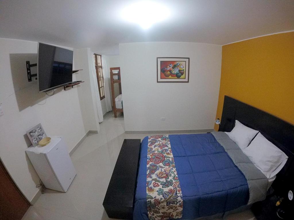 1 dormitorio con 1 cama y TV. en Jazmines Lodging, en Ica