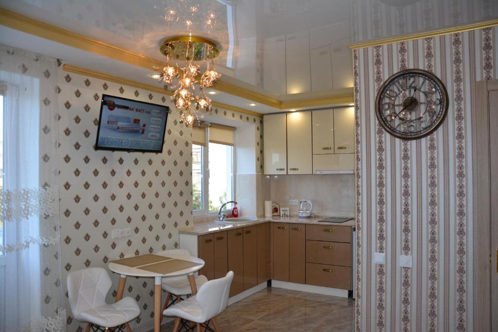 a kitchen with a table and a clock on the wall at Apartaments on Preobrazhenskaya 8 in Kropyvnytskyi