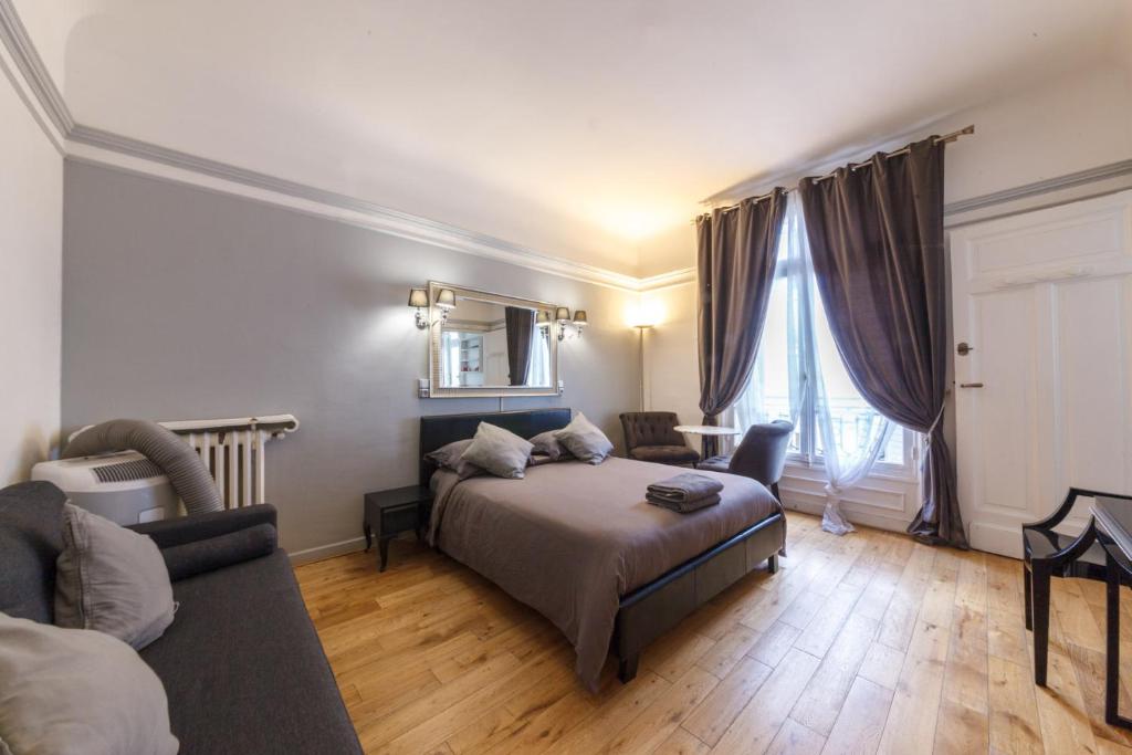 パリにあるPrivate Studio - Avenue des Champs-Elyséesのベッドルーム1室(ベッド1台付)、リビングルームが備わります。