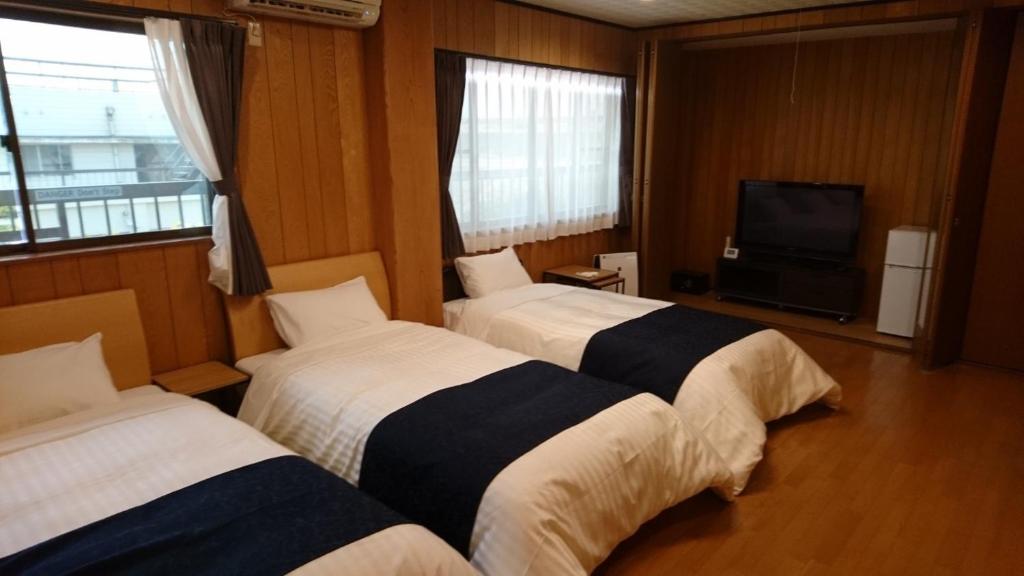 a hotel room with two beds and a television at Minpaku Nagashima room3 / Vacation STAY 1035 in Kuwana