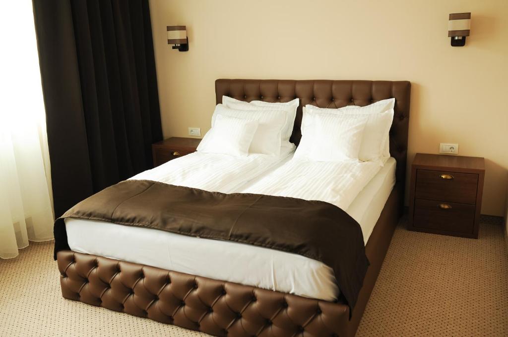 a bedroom with a large bed with a leather headboard at Vine Rooms in Oradea